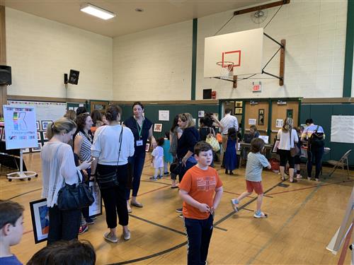 Art Show 2019 students and adults with art in gym 